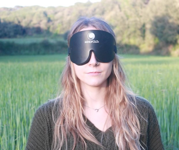 Una participante con el antifaz Mindfold puesto, al aire libre